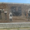 An old fashioned postal scene painted on the side of a post office in Omro, WI.