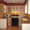 Galley kitchen with white cabinets with brown doors with a white window frame treatment