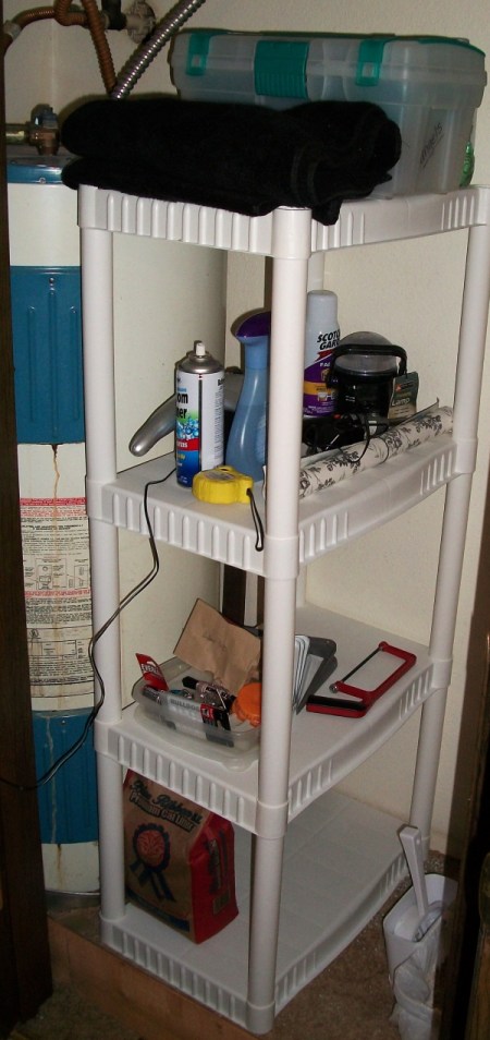 A shelf for extra bathroom and cleaning storage, next to the water heater.