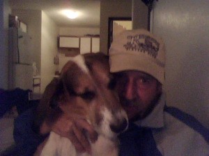 man in baseball cap holding a tricolor dog