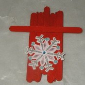 red painted sled with snowflake decoration affixed to top side