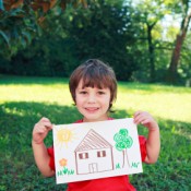 Little boy holding a drawing.