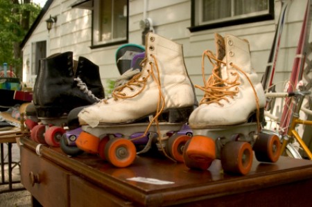 Two pair of roller skates on table at a garage sale.