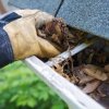 Hand cleaning leaves out of rain gutters 2