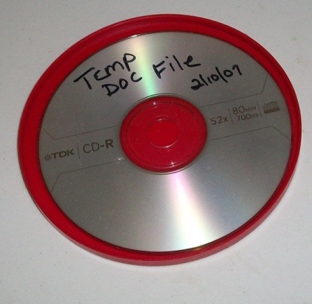 An oatmeal lid used to hold a burned CD.