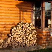 Firewood stacked against the side of a house.