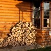 Firewood stacked against the side of a house.