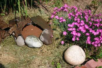 Photo of a butterfly garden pond, a circle of rocks with water in it.