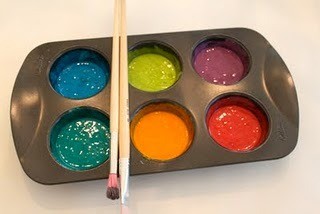 Muffin tin with puffy paint and brushes.