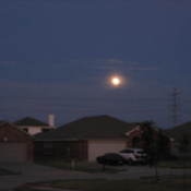 A full moon over a neighborhood.