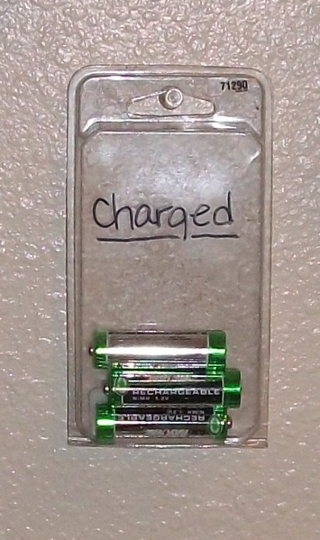 Plastic adhesive nail packing with batteries inside and "charged" written on the outside