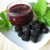 Blackberry Jam Recipes, Jar of blackberry jam on a plate with fresh blackberries.