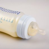 Saving Money on Baby Formula, Baby bottle laying on its side with formula in it.