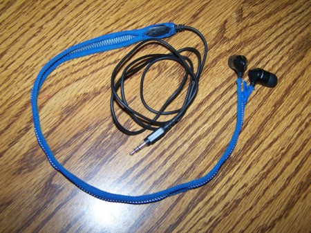 blue zippered earbud cord case with earbuds inside ling on a table