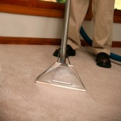 Man Steam Cleaning a Carpet