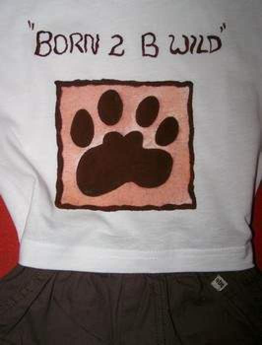 A baby's onsie with a fabric paint design of a paw and the words "Born 2 B Wild".