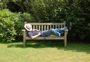 Man snoozing on garden bench