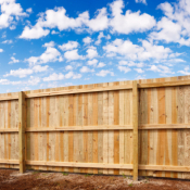 Building a Fence, Six Foot Tall Cedar Fence with Blue Sky in the Background