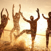 People playing on the beach at sunset.