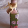 bath salt bottle wrapped in floral paper sealed with a cork top edge wrapped in tied raffia with a tag