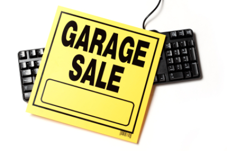 Garage Sale sign laying over top of a black keyboard