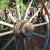 Antique Wagon Wheels Leaning Against Chain Link Fence