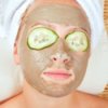 Woman with facial mask and cukes on eyes.