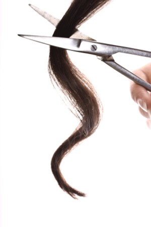 Scissors cutting a lock of dark hair.