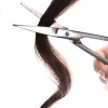 Scissors cutting a lock of dark hair.