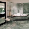 A marble spa tub and floor in a beautiful bathroom.