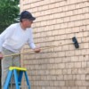 Man Cleaning Wood Siding