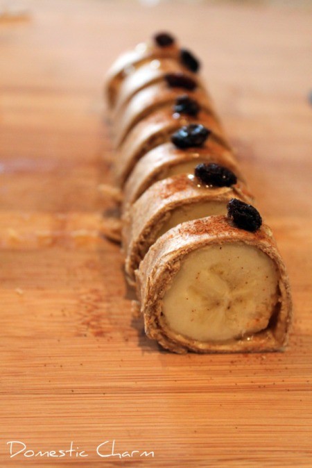 A banana rolled up in a tortilla with peanut butter and a raisin to look like sushi.