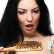 Woman Looking Shocked at the Hair in Her Brush