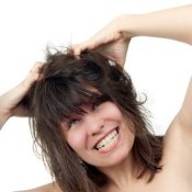 Young woman scratching her head furiously.