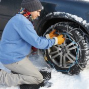 Man Putting Chains on His Car in the Snow