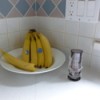 Small vase and bowl of bananas on kitchen counter