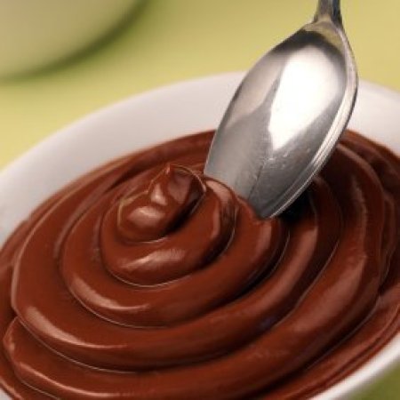 Chocolate pudding in a bowl with a spoon.