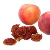 Peach pits and fruit on white background.