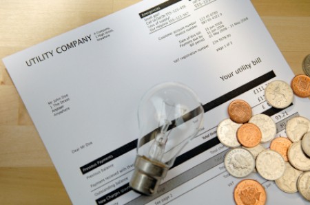Saving Money on Your Electric Bill, Money and Light Bulb on Top of Electric Bill