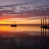 A colorful sunrise over the Puget Sound, with a boat and dock.