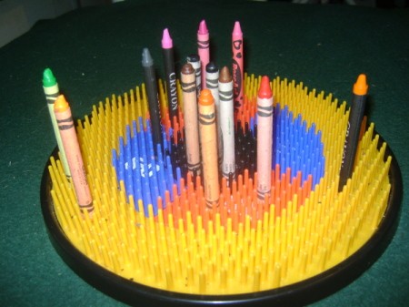 A plastic dartboard used for storing crayons.