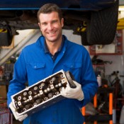 Finding an Honest Mechanic, Mechanic Holding up Car Part in Front of Car
