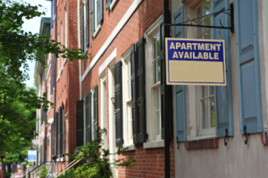 An street with an "Apartment For Rent" sign.