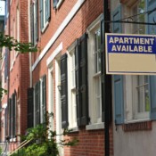 An street with an "Apartment For Rent" sign.