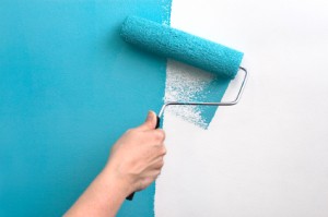 Paint Roller Putting Teal Paint on Wall