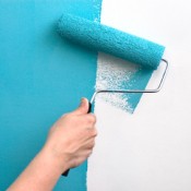 Paint Roller Putting Teal Paint on Wall