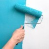 Paint Roller Putting Teal Paint on Wall