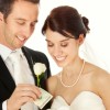 Bride and Groom Putting Money in Piggy Bank
