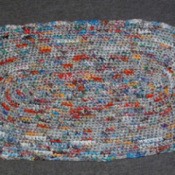 Multicolored crocheted oval rug.