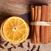 Dried orange slices, bundle of cinnamon sticks, and cloves.